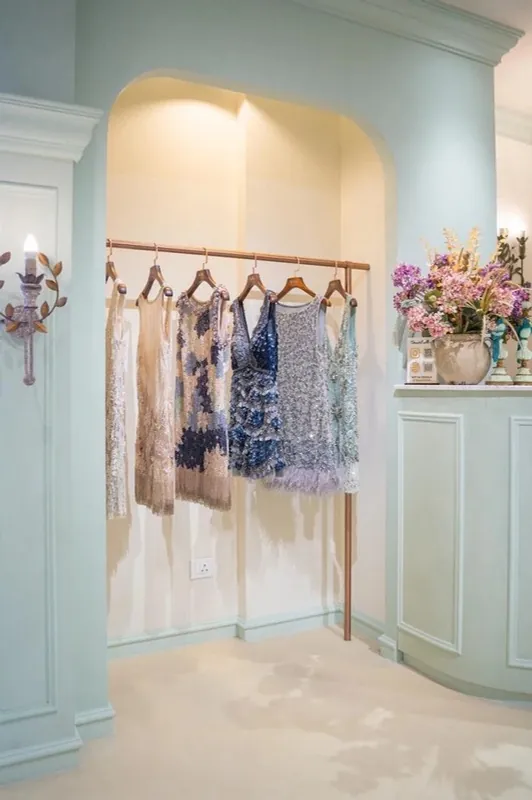 Arched mint-panelled niche with hanging dresses at NSS