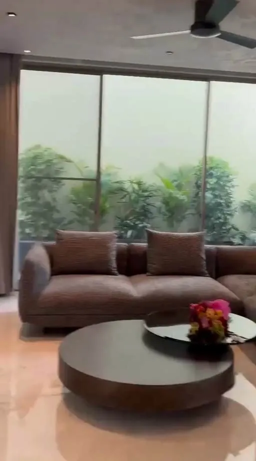 Garden-facing living room with textured walls — Organic Tattva project