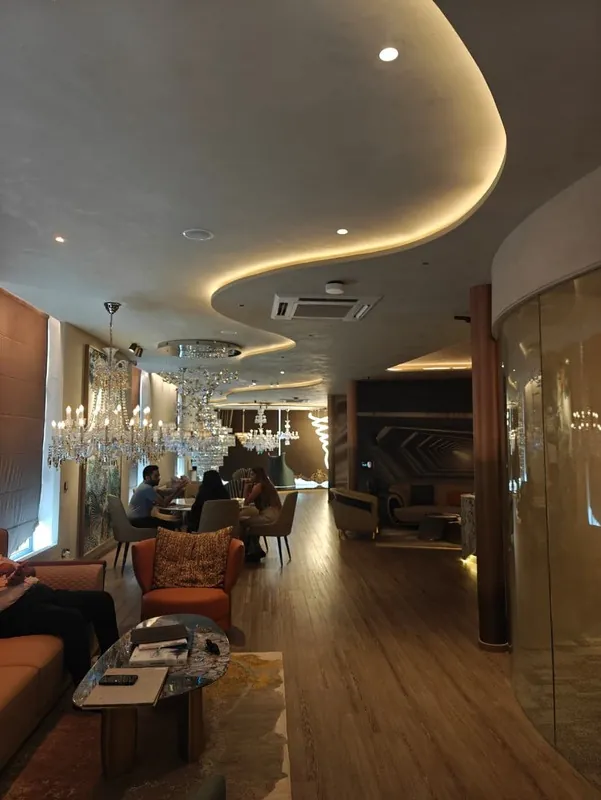 Open lounge with curved cove ceiling and timber flooring at Savano Lustre