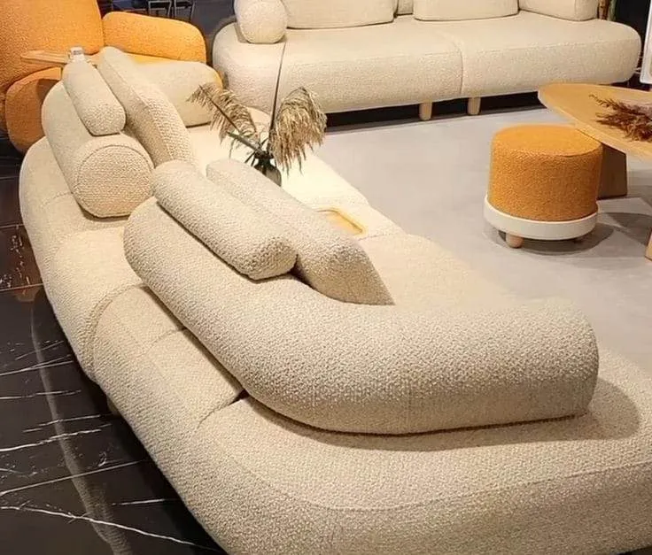 Curved cream bouclé sofa with orange ottoman